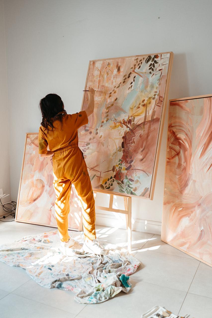 Hayley Lombard working on a large commissioned canvas in her sunlit studio