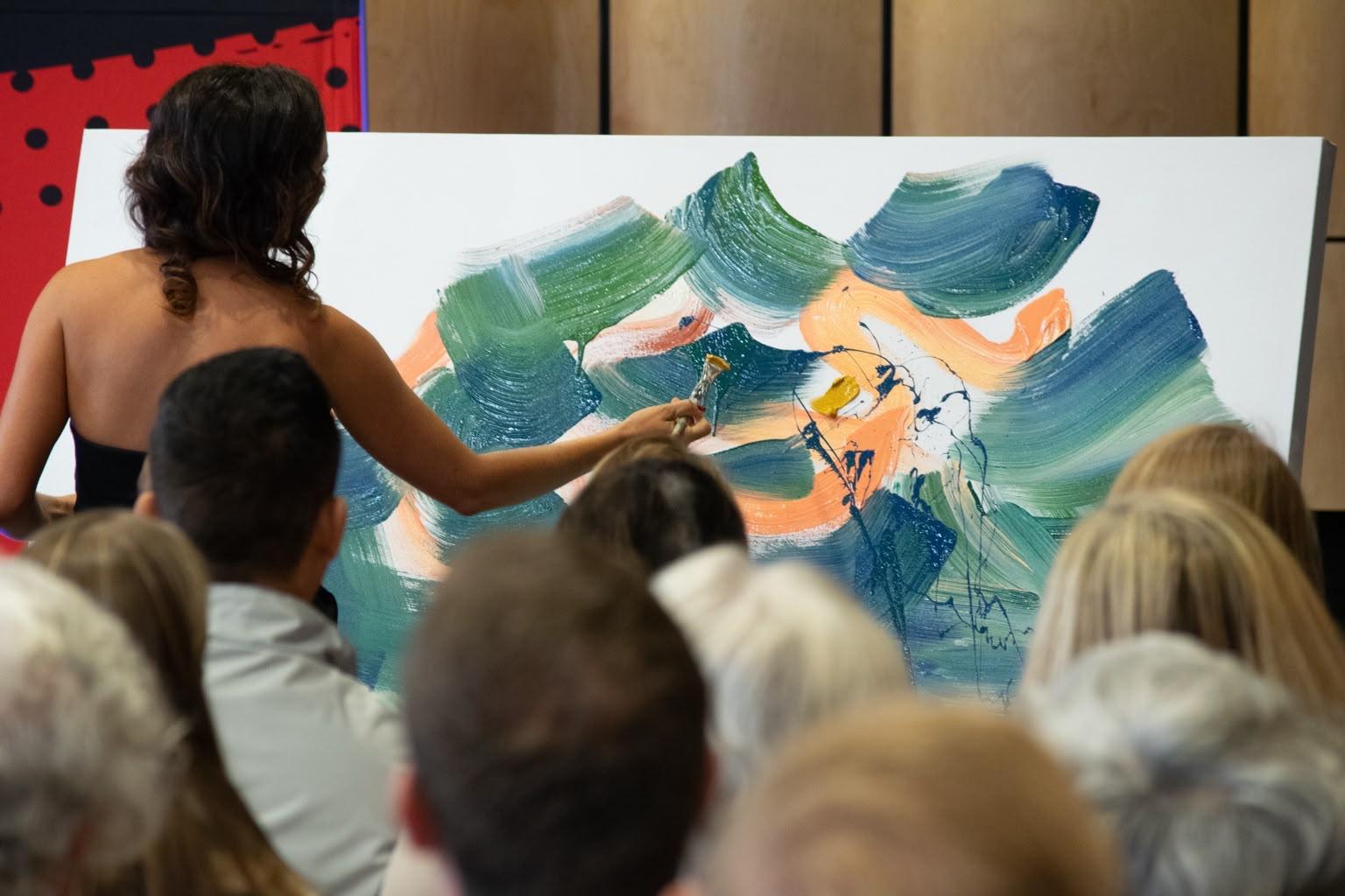 Hayley Lombard live painting on stage before an audience